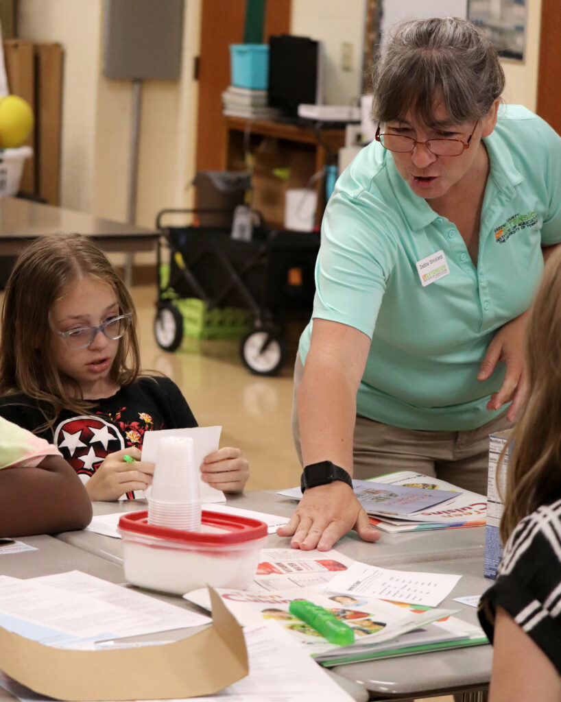 Extension PA working with two kids on a worksheet at a table