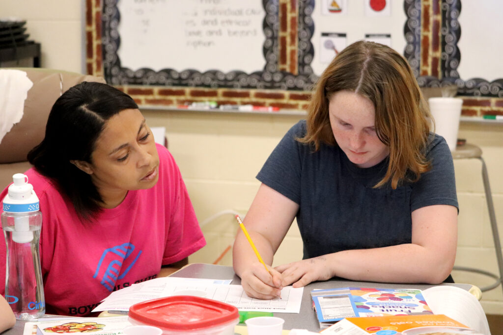 teacher and student working on worksheet at table