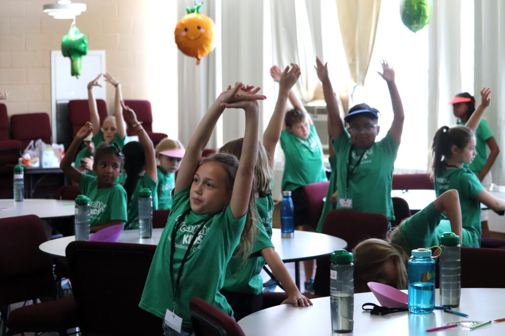 kids in class taking a stretch break at their seats in the classroom