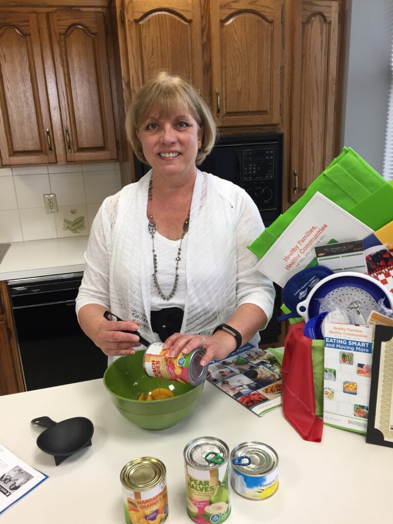 lady pouring canned fruit into a bowl and smiling