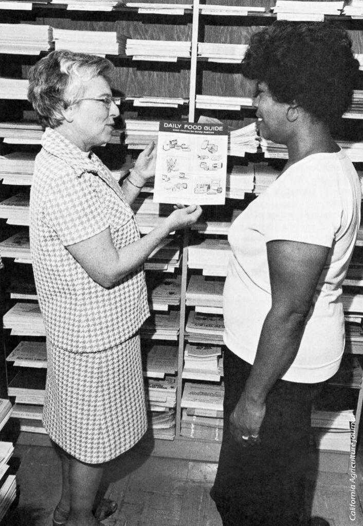 black and white picture of agent talking with participant holding up a flyer