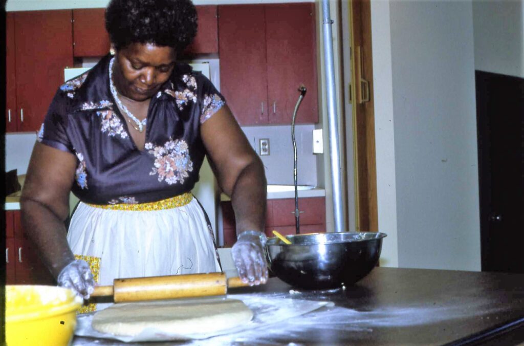 lady rolling out dough on kitchen counter top